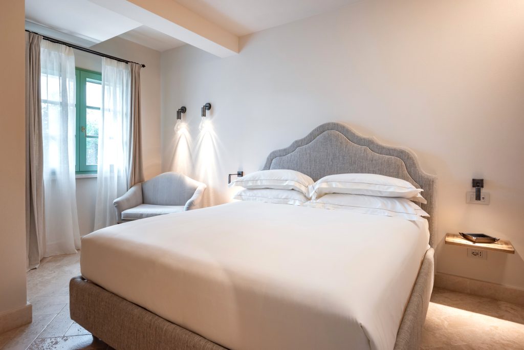 Camera da letto dell'appartamento Grecale nell'agriturismo in toscana con piscina Terre dei Ghelfi: stanza da letto con letto matrimoniale e luci soffuse che creano ambientazione tranquilla e rilassata