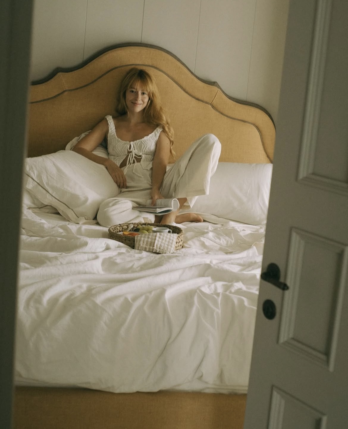 Post Instagram ragazza sul letto dell'appartamento Tramontana nell'agriturismo toscano Bolgheri Terre dei Ghelfi