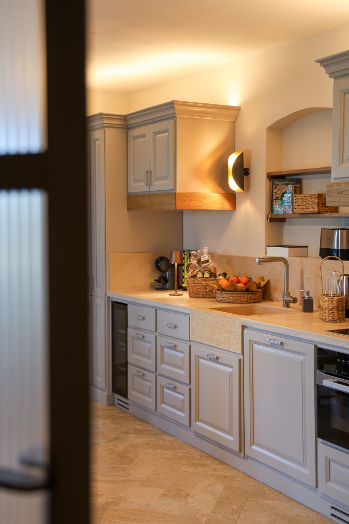 Cucina appartamento Tramontana per un relax nell'agriturismo in toscana: cucina bianca con luci soffuse che creano atmosfera rilassata e casalinga